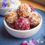 Gesunde Energie-Bällchen mit Datteln und Himbeeren auf einem Teller