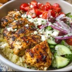 Griechische Hähnchenschüssel mit frischen Zutaten und Gewürzen.