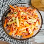 Karotten-Apfel-Salat mit frischen Zutaten in einer Schüssel