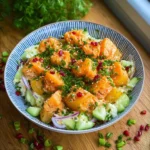 Frischer Kartoffelsalat mit Kräutern und Dressing auf einem Teller serviert.