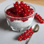 Gesunder Chia-Pudding mit Johannisbeeren in einer Schale serviert.