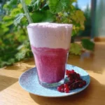 Johannisbeer-Vanille-Shake in einem Glas, dekoriert mit frischen Johannisbeeren.