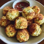 Knusprige Zucchini-Feta-Bällchen frisch zubereitet auf einem Teller