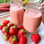 Erfrischender Schneller Rhabarber-Smoothie mit Erdbeeren in einem Glas mit frischen Zutaten