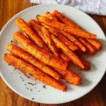 Köstliche Karotten aus der Heißluftfritteuse auf einem Teller serviert.