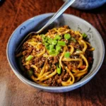 Schüssel mit mongolischer Hackfleisch-Pasta, garniert mit frischen Kräutern