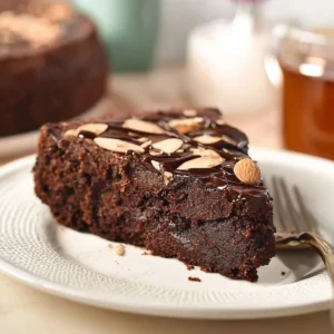 Schokoladenkuchen ohne Mehl auf einem Teller, verziert mit Schokoladenspänen